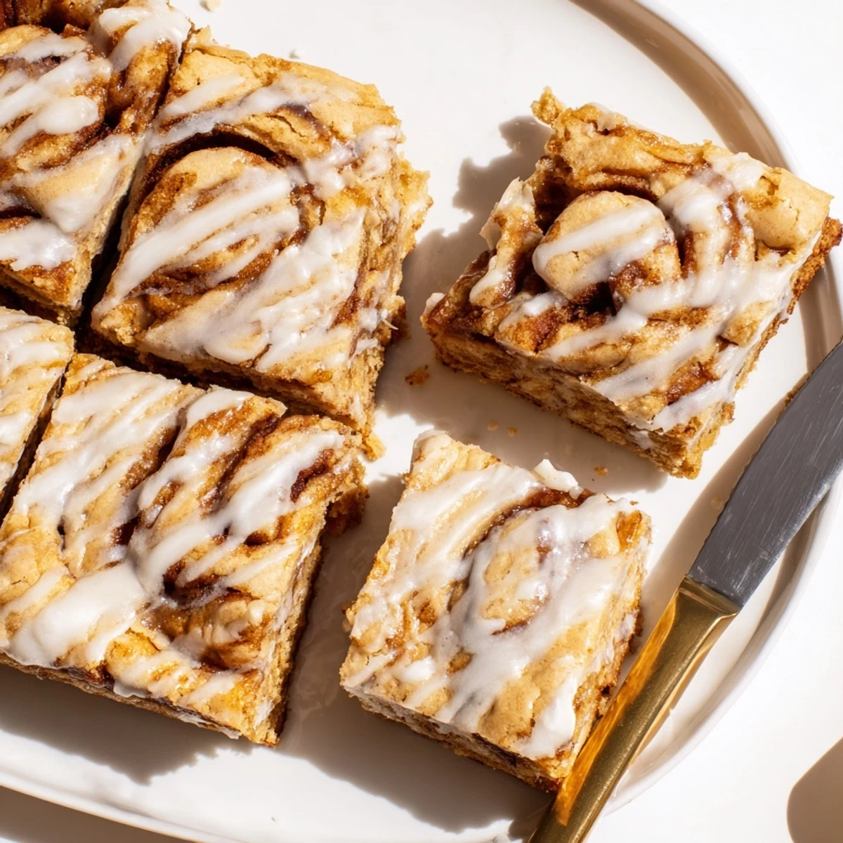 Soft cinnamon roll cookie bars drizzled with creamy vanilla glaze for a sweet treat.
