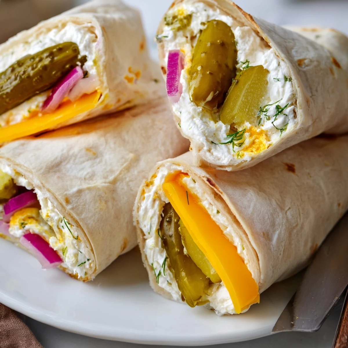 Crisp pickle-in-a-blanket rolls with creamy cheese, perfect for appetizers at parties.  