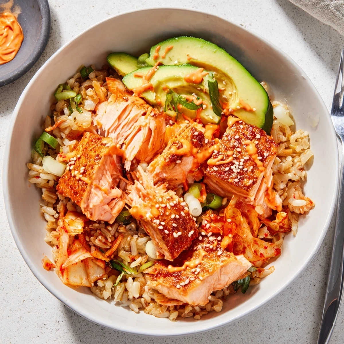 A delicious crispy salmon rice bowl topped with spicy mayo and fresh avocado.  