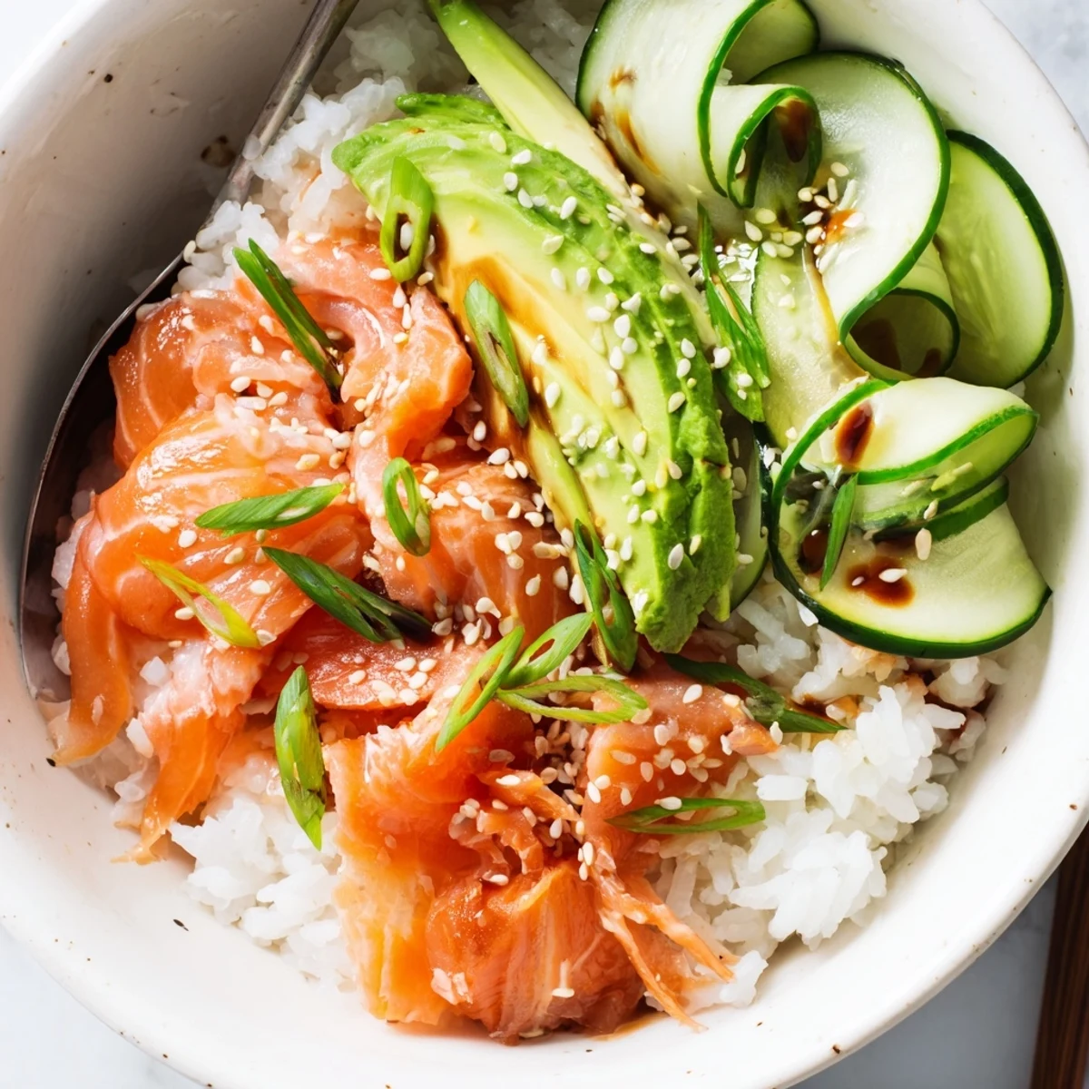 A delicious Leftover Salmon & Rice Bowl topped with fresh avocado and cucumber slices.  