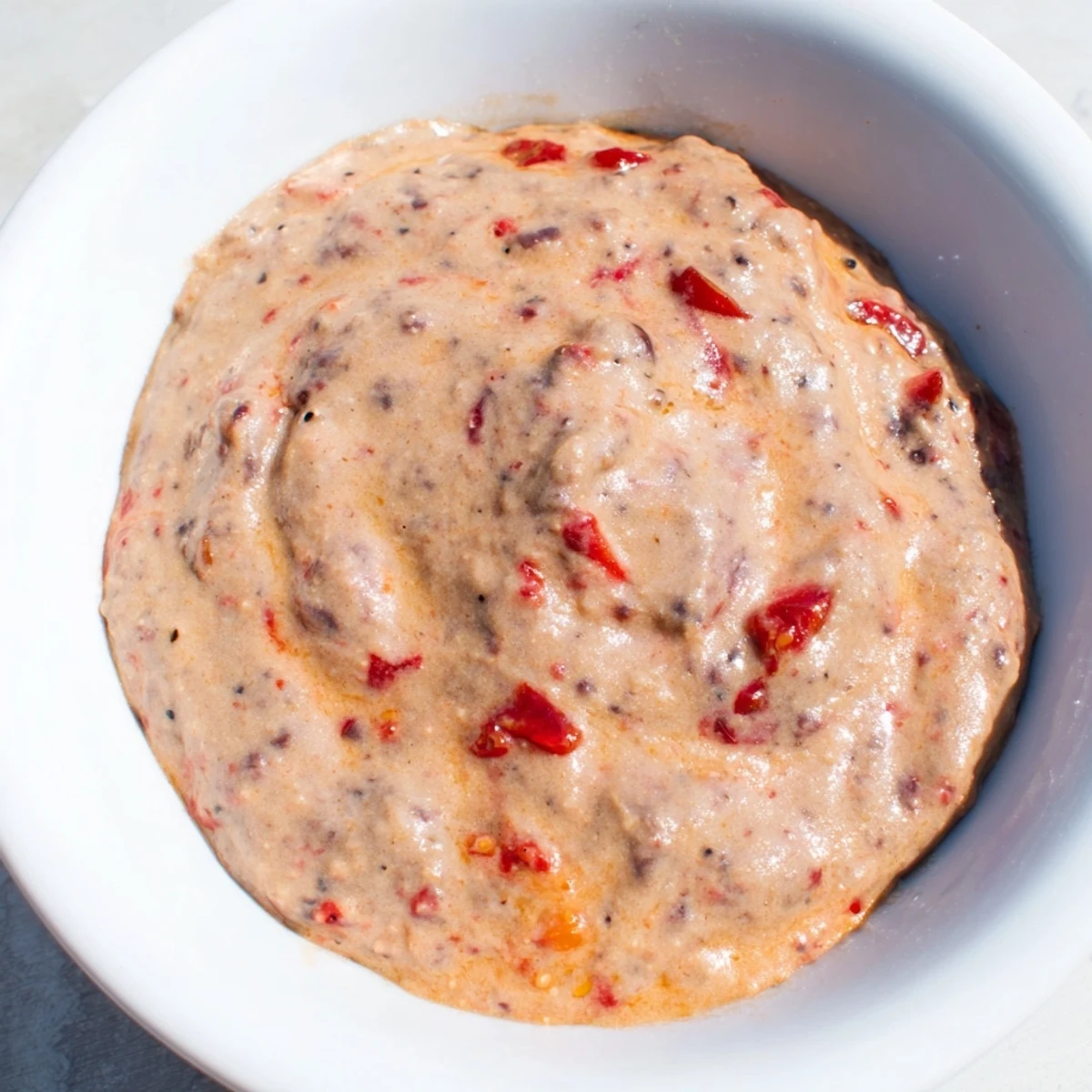 A close-up of delicious Spicy Black Bean Dip; imagine the rich textures and bold flavors, served cold.