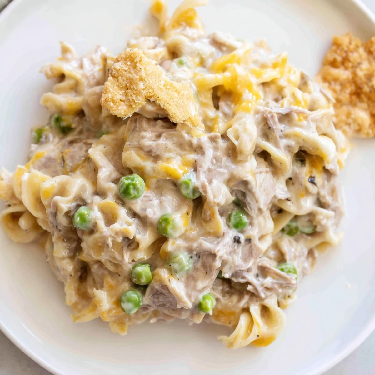 Warm, creamy tuna noodle casserole topped with buttery, toasted Ritz crackers in a baking dish.