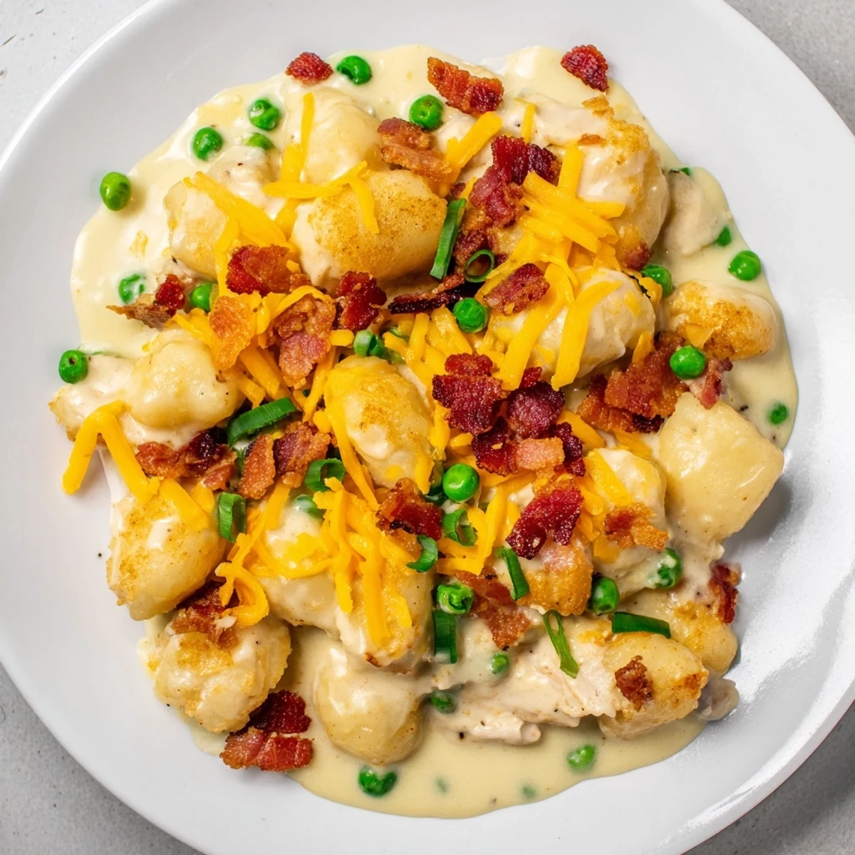 A hearty bowl of Creamy Crack Chicken Gnocchi, showcasing tender chicken with bacon and peas.