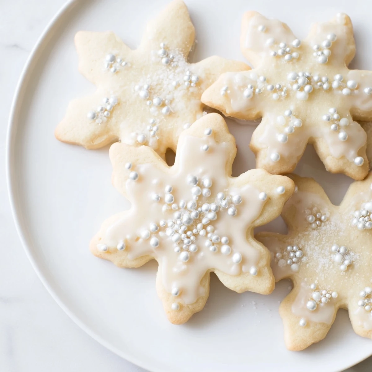 A close-up of our Winter Snowflake Platter filled with white chocolate-covered snowflake cookies and silver sprinkles.