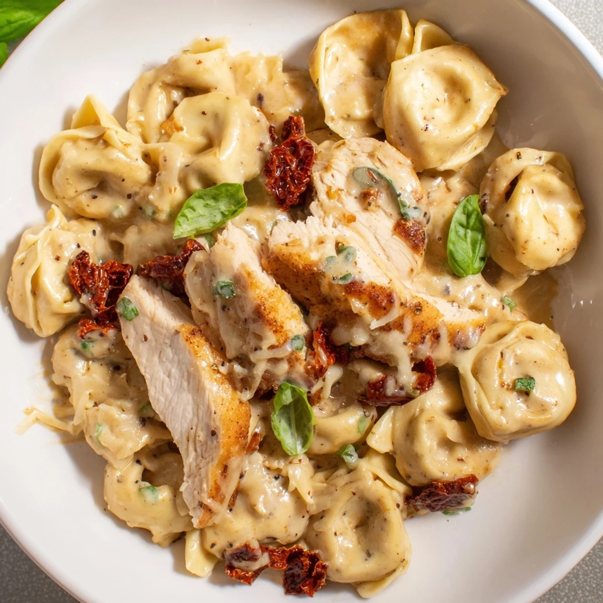 Warm Marry Me Chicken Tortellini with creamy sauce and fresh basil, ready to serve and enjoy.