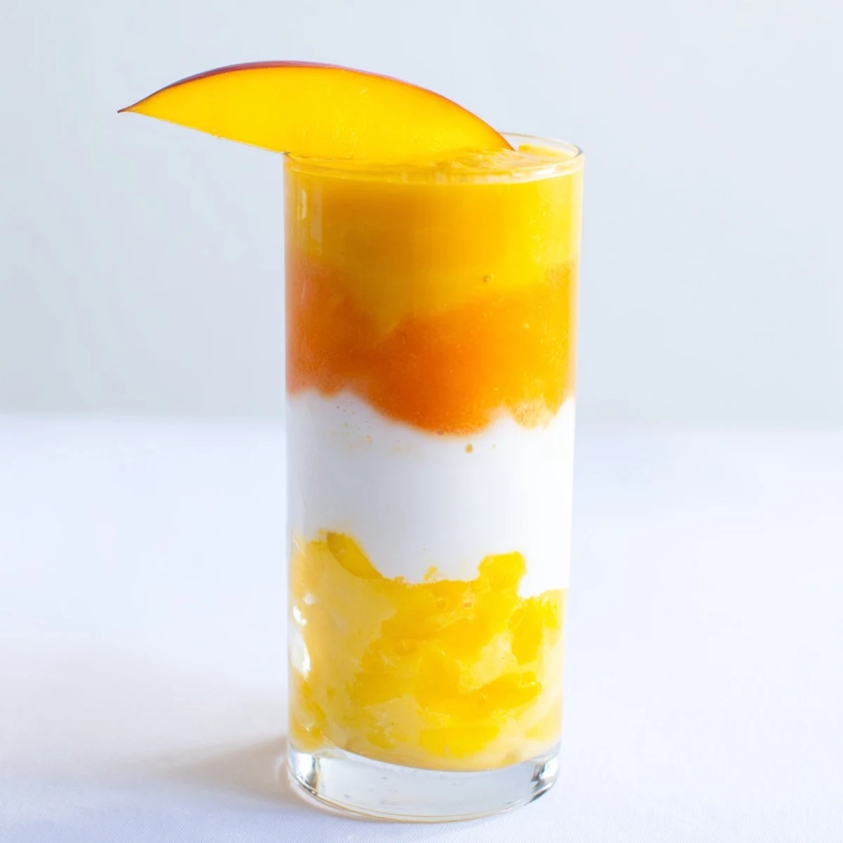 Layered Tropical Sunset Smoothie with vibrant mango and passion fruit, a refreshing and beautiful beverage.
