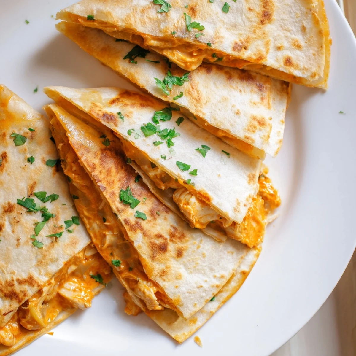 A close-up view of butter chicken quesadillas with a melted cheese interior and crispy tortillas.