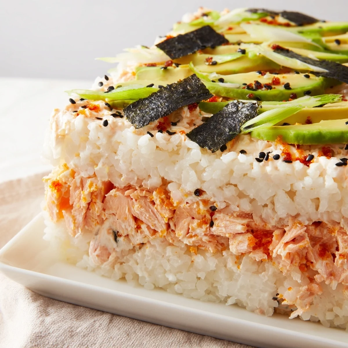Sushi Bake casserole, warm and golden, with creamy avocado and flaked salmon on top.