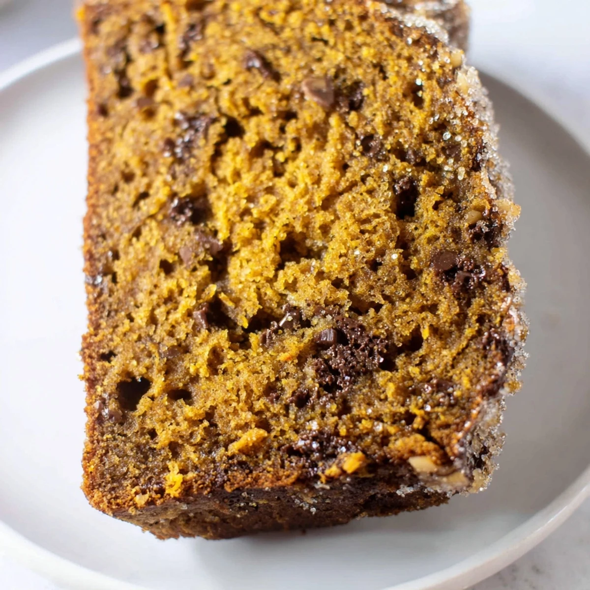 Moist and tender pumpkin bread loaf, beautifully textured, inviting you to imagine its warm flavors.