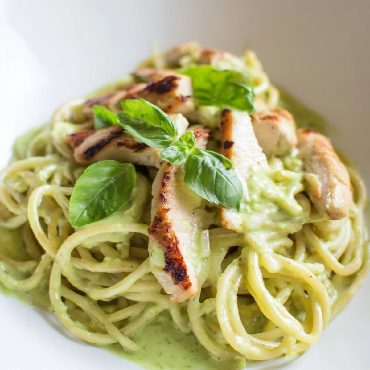 Creamy Avocado Chicken Pasta plated with creamy green sauce, lemon zest, and basil, ready for a quick, nourishing dinner.