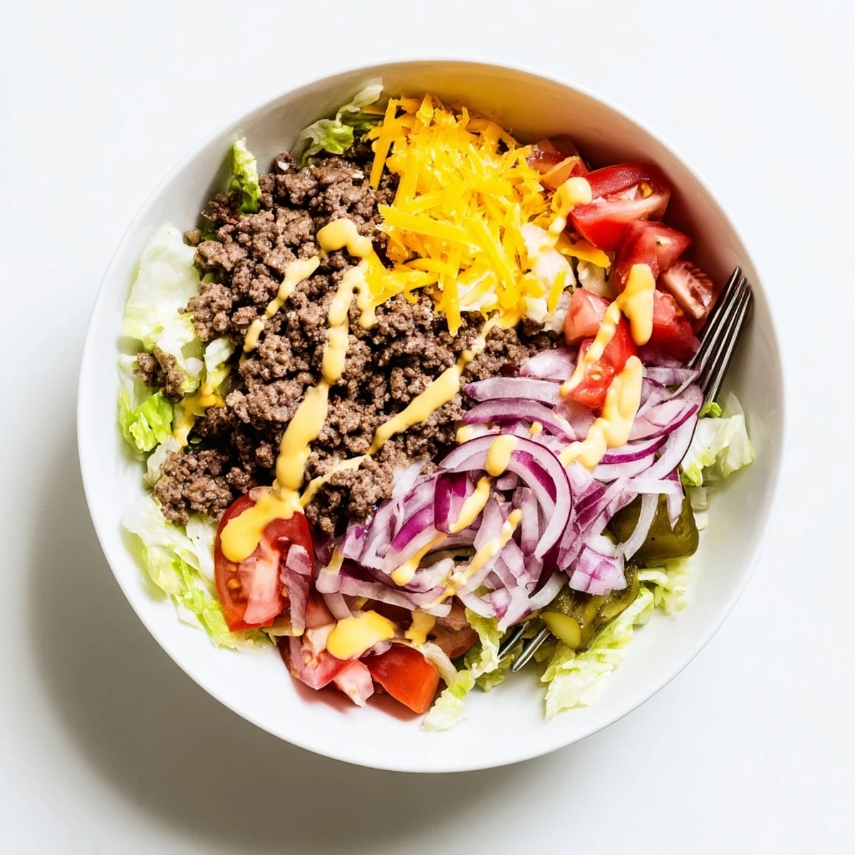 A close-up of Easy Big Mac in a Bowl with seasoned ground beef, crisp lettuce, and melted cheddar.