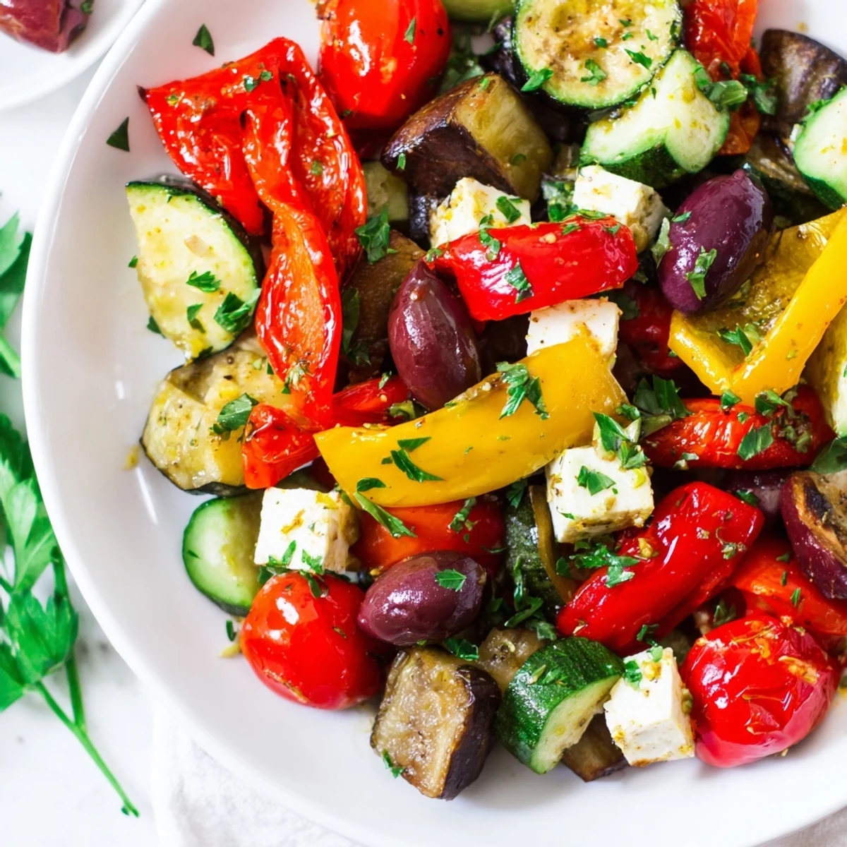 This vibrant Roasted Greek Salad is served warm over cucumber slices, finished with fresh parsley and a crumble of feta.
