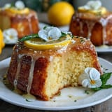 Moist lemon drizzle cake topped with tangy glaze and delicate edible flowers, perfect for Mothers Day celebrations and afternoon tea.