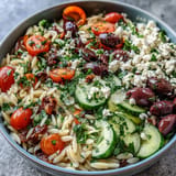 A healthy Mediterranean Orzo Bowl featuring tender pasta, fresh veggies, and lemon dressing.