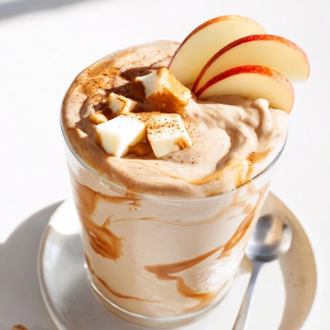 Creamy Peanut Butter Apple Fall Smoothie, swirled in a glass, with cinnamon dusting.