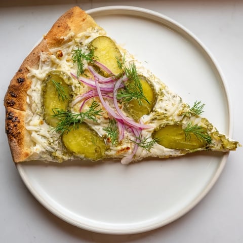Tangy Pickle Pizza with creamy sauce and fresh dill, perfect for adventurous eaters.  