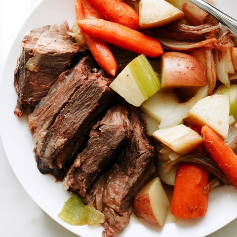 Tender Sunday Pot Roast surrounded by colorful roasted veggies, ideal for family meals.  