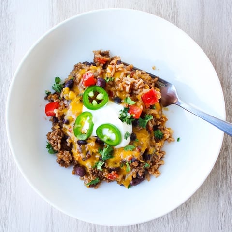 Hearty Tex-Mex Beef & Rice Casserole with melted cheese and vibrant toppings.  