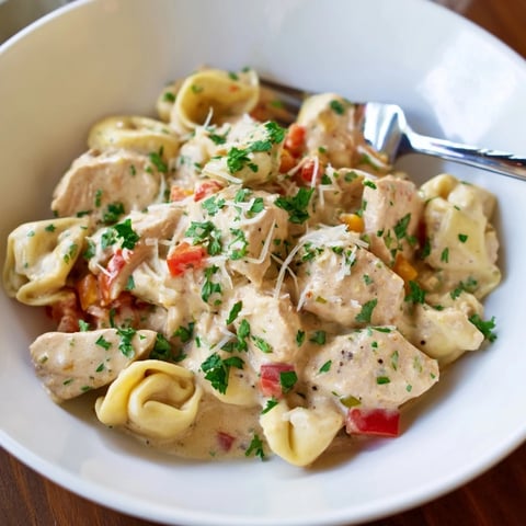 Zesty Cajun Garlic Parmesan Chicken Tortellini in a creamy sauce, garnished with fresh parsley.  