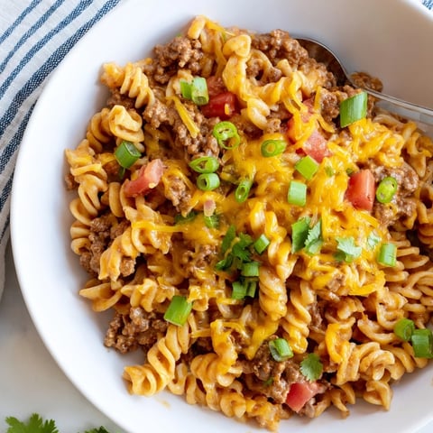 Flavorful Cheesy Taco Pasta Skillet, a bubbling one-pan meal with melted cheese and fresh herbs.
