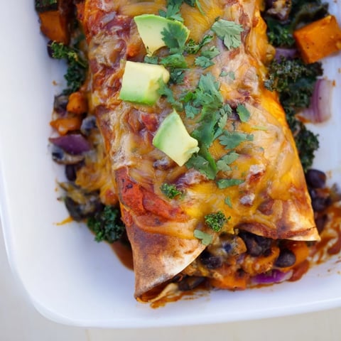 One-pan sweet potato, black bean & kale enchiladas baking with bubbly cheese, a delicious, layered main dish.