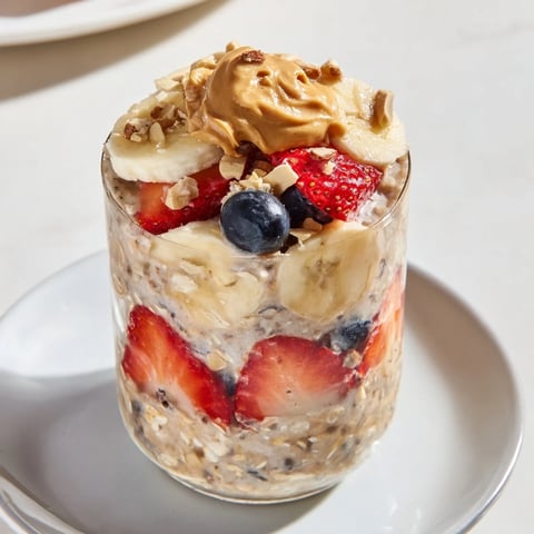 Layers of vibrant fruit and peanut butter top delicious Overnight Oats Jars, ready for breakfast.
