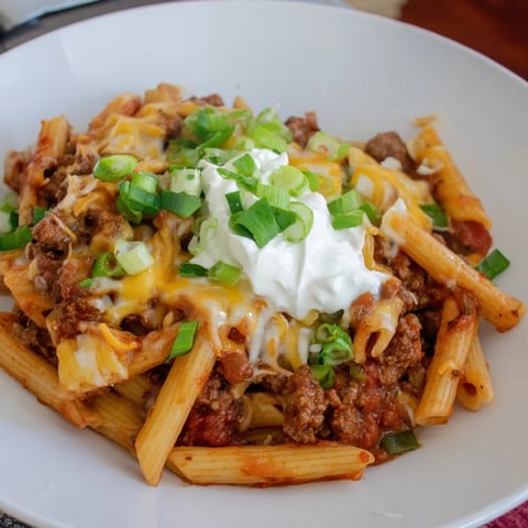 Easy beef enchilada pasta: a bubbling, cheesy skillet of ground beef and rotini, ready to serve.
