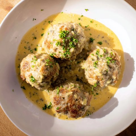 Golden-brown turkey meatballs simmering in a rich pumpkin sage sauce.