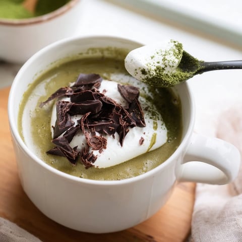 Matcha hot cocoa protein mug, a delicious, vibrant green drink with frothy whipped cream topping.