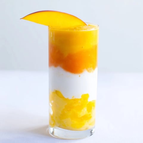 Layered Tropical Sunset Smoothie with vibrant mango and passion fruit, a refreshing and beautiful beverage.