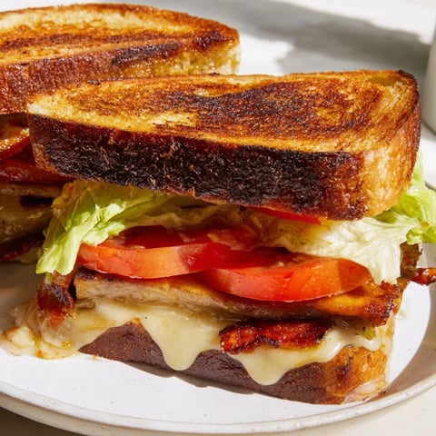 Golden-brown Vegan Bacon BLT Grilled Cheese with melty vegan cheese, smoky tempeh bacon, and fresh lettuce on buttery sourdough.