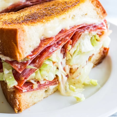 Golden-brown Italian Sub Grilled Cheese sandwich with melted provolone, salami, and pepperoni on buttery bread.  