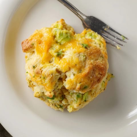 Close-up of baked Avocado Cheddar Breakfast Biscuits showcasing the cheddar and chives inside.