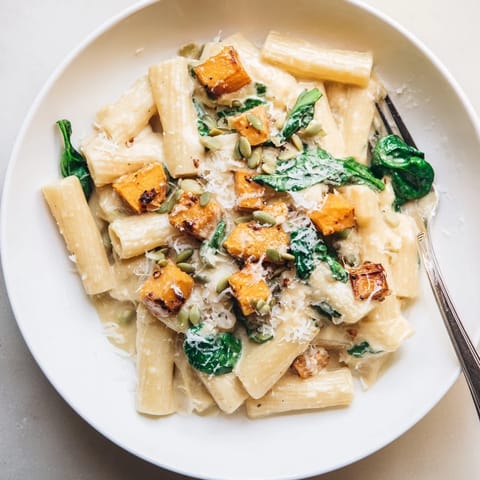 A warm bowl of Creamy Miso Fall Pasta topped with roasted squash and herbs.  
