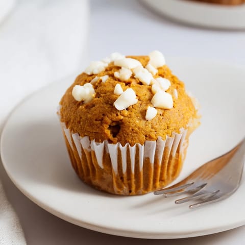 Delicious pumpkin muffins loaded with creamy white chocolate chunks for cozy mornings.  