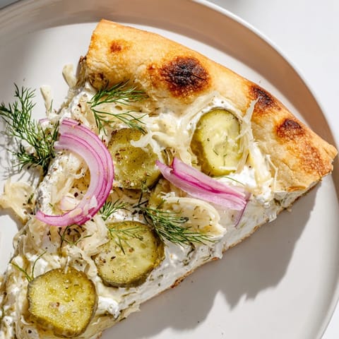 Deliciously cheesy Pickle Pizza topped with crunchy pickles and garlic crème fraîche.  