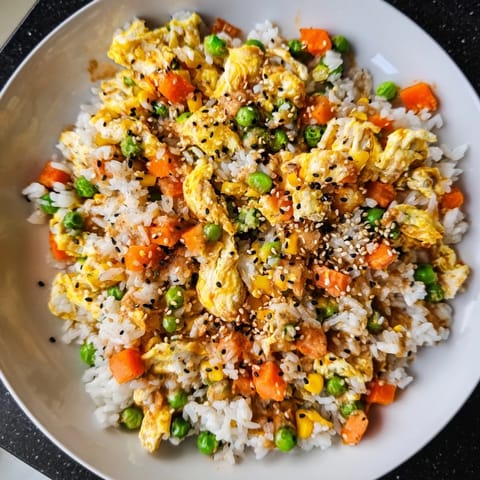 This colorful image shows a delicious bowl of homemade Frozen Veggie Fried Rice garnished with green onions.