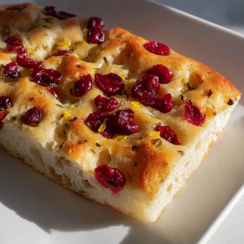 Enjoy this easy homemade cranberry orange focaccia, boasting a delightful combination of sweet and zesty flavors.