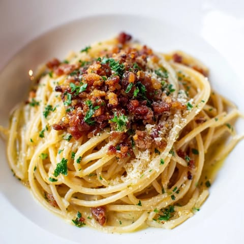 A close-up view of Garlic Butter Pasta with Crispy Bacon Crumble, perfectly plated with fresh parsley garnish.