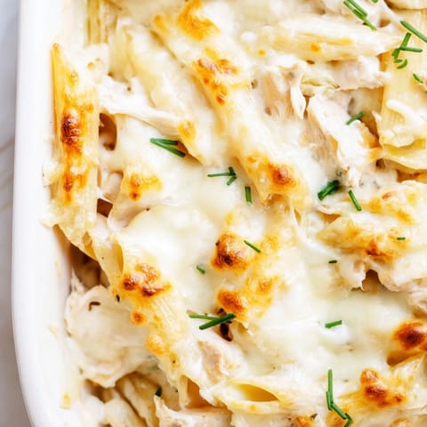 A close-up of the creamy Chicken Ranch Pasta Bake, featuring tender chicken and penne pasta covered in melted cheese.