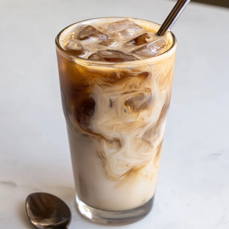 Refreshing tahini iced coffee topped with almond milk, perfect for a summer treat.  