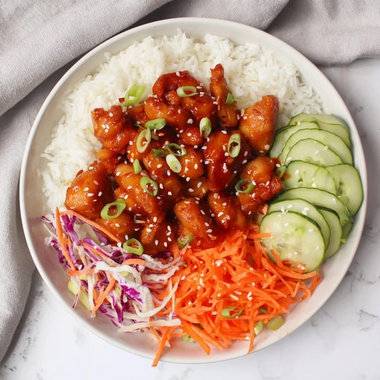 A visually appealing rice bowl with tender chicken in a vibrant Sriracha honey glaze, ready to enjoy.