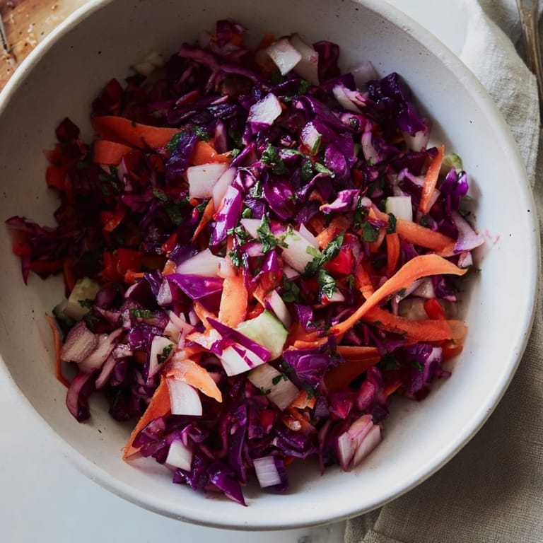 Freshly tossed Shirazi-Inspired Winter Slaw, featuring shredded cabbage, crisp carrots, and herbs, ready to serve.