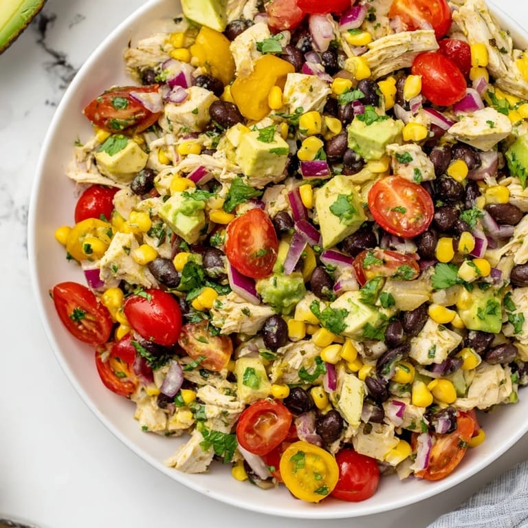 A colorful bowl of Dense Southwestern Bean Salad, with creamy avocado and zesty dressing, perfect for any gathering.