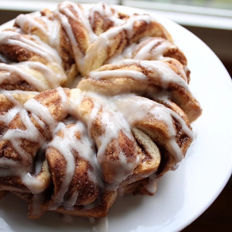 Warm, soft cinnamon roll snowflake, a beautiful holiday breakfast with sweet vanilla icing drizzled all over.