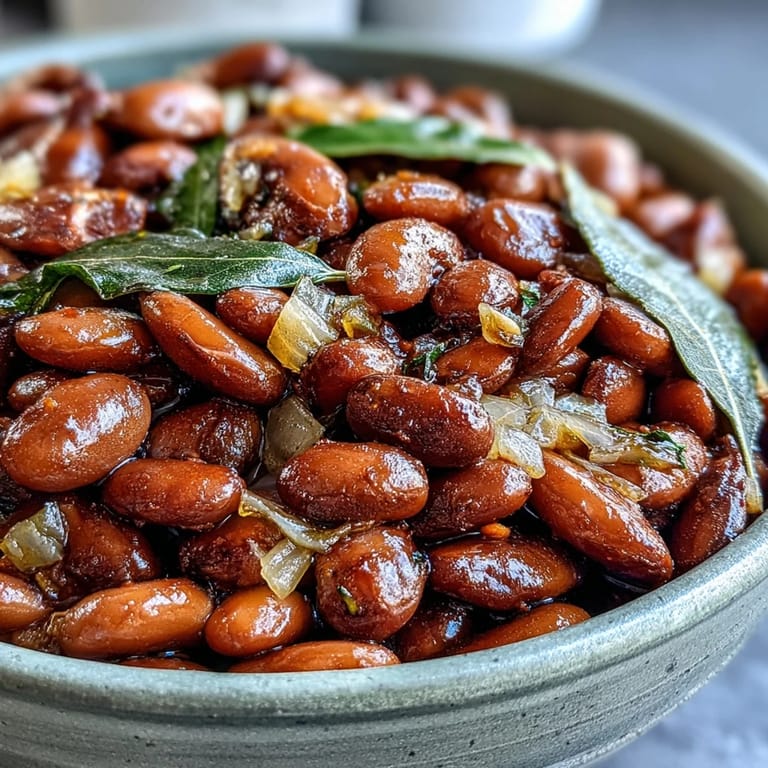 Hearty pinto beans garnished with fresh cilantro, ready to serve as a side.