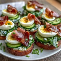 A playful snack plate with green scrambled eggs, rolled ham slices, and crackers for kids, inspired by Dr. Seuss.  