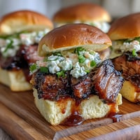 Smoky pulled pork piled high on soft slider buns, topped with creamy coleslaw for baby shower sliders.  
