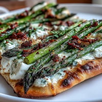 Roasted asparagus flatbread topped with creamy burrata, vibrant lemon zest.